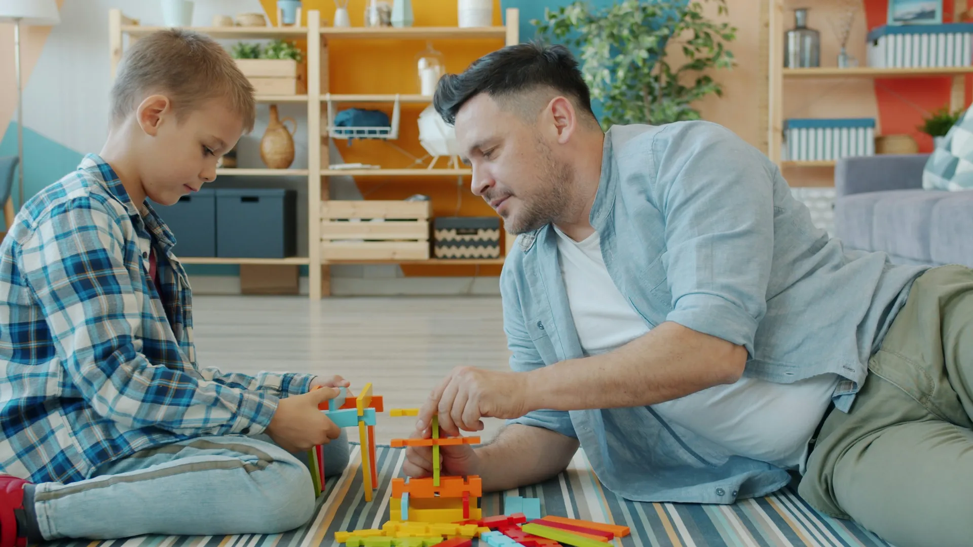 A parent and young child laughing and playing together with colorful toys
